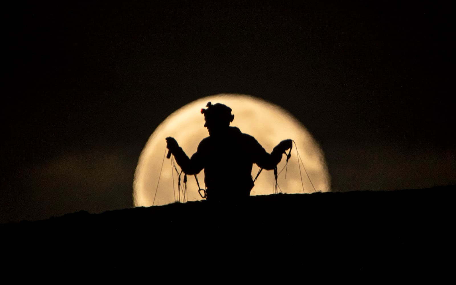 Parapentiste devant la pleine lune